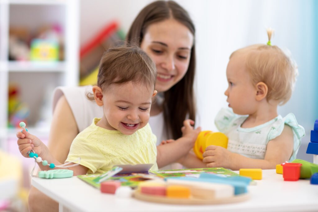 nursery teacher and cute babies playing in creche